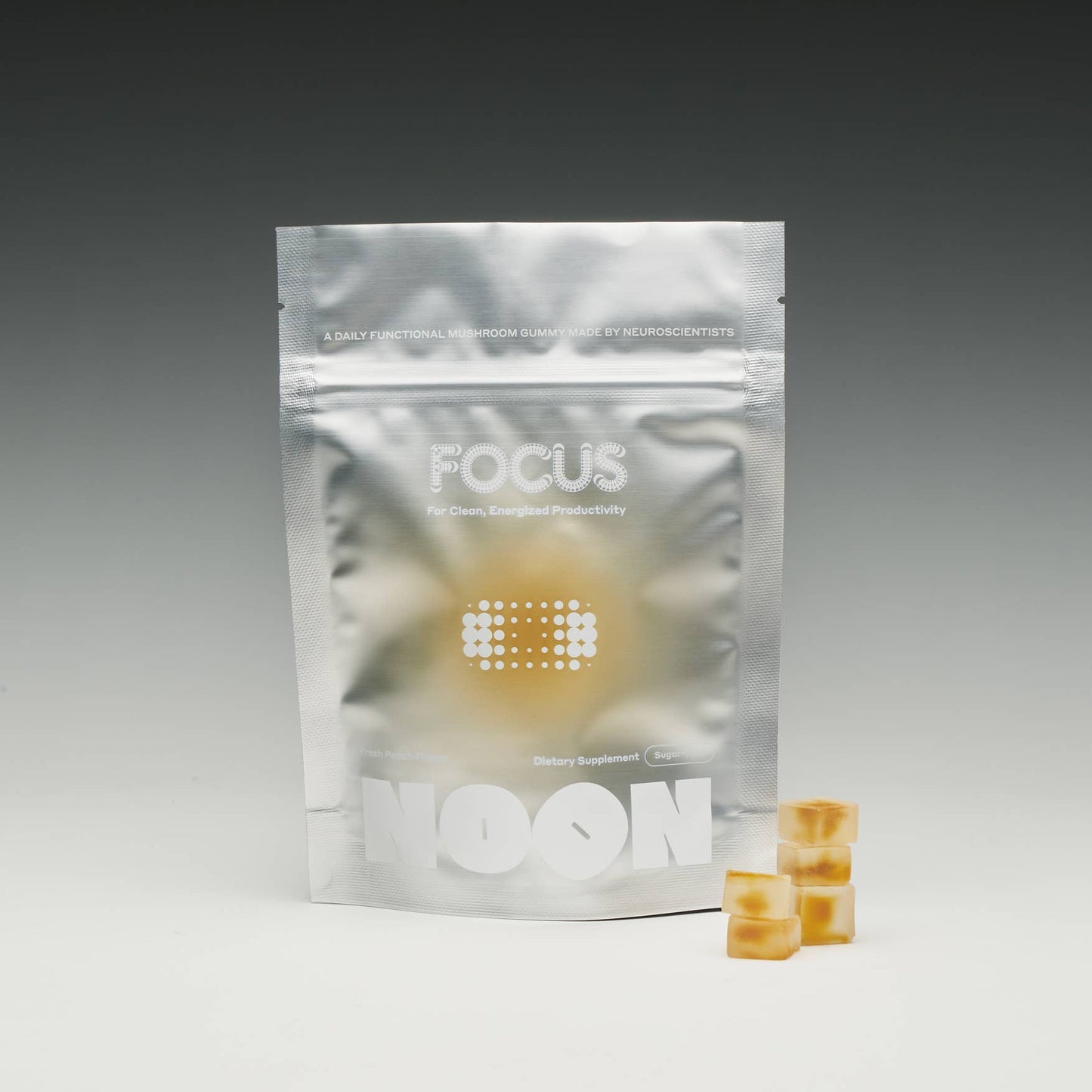 Silver 'FOCUS' package with two yellow capsules on a gray background
