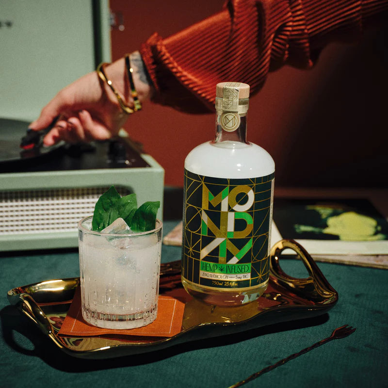 Bottle of Mondial Vodka with a glass of cocktail on a tray, with a person in the background.
